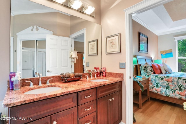 bathroom with wood finished floors, ensuite bath, crown molding, and a sink