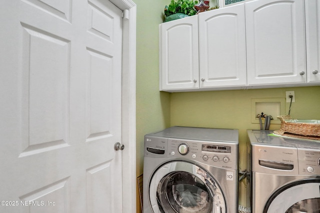 washroom featuring cabinet space and washing machine and clothes dryer