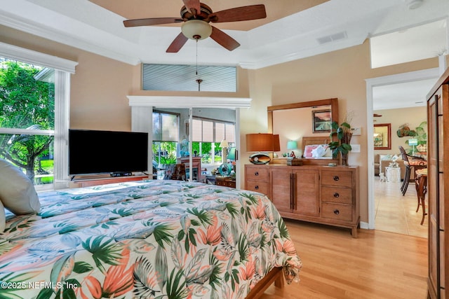 bedroom featuring crown molding, light wood-style flooring, and visible vents