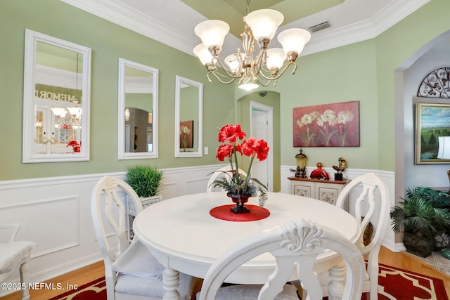 dining room featuring wainscoting, visible vents, and light wood-style flooring