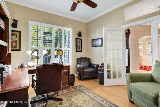 office featuring wood finished floors, arched walkways, ceiling fan, ornamental molding, and french doors