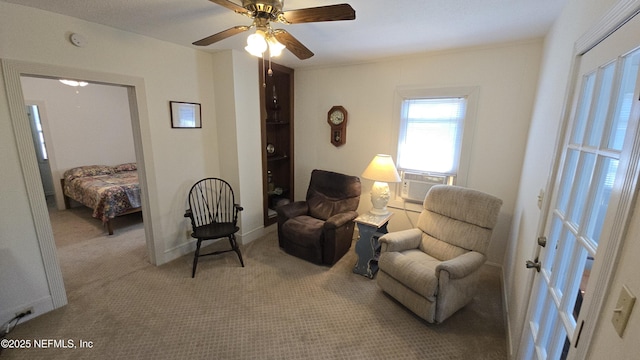 sitting room featuring cooling unit, carpet floors, baseboards, and ceiling fan