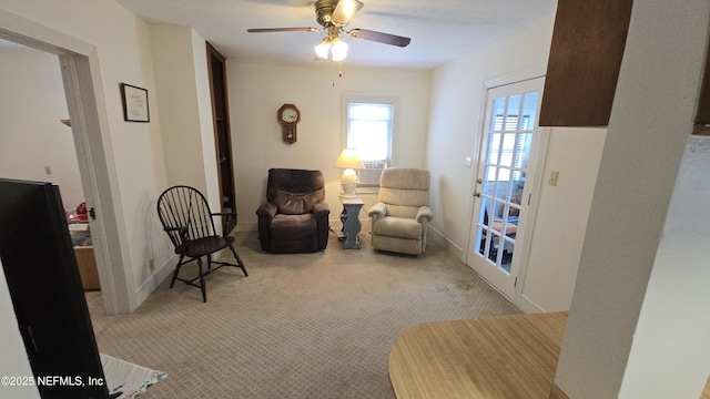 sitting room with ceiling fan, baseboards, and carpet