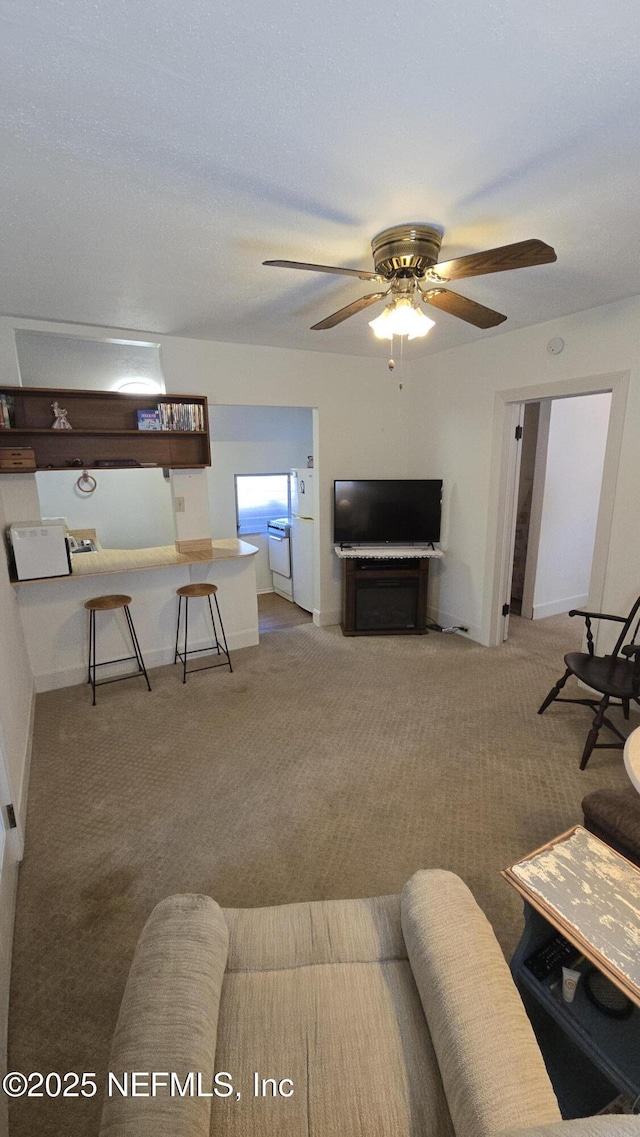 carpeted living area featuring a ceiling fan