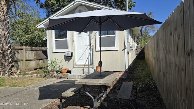 view of outbuilding featuring entry steps, an outdoor structure, and a fenced backyard