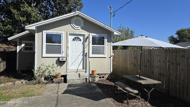 view of outdoor structure with entry steps, an outbuilding, and fence