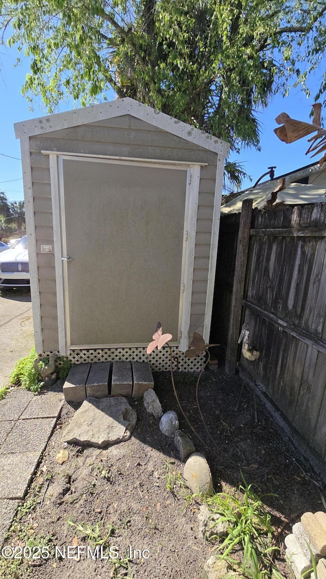 view of shed featuring fence