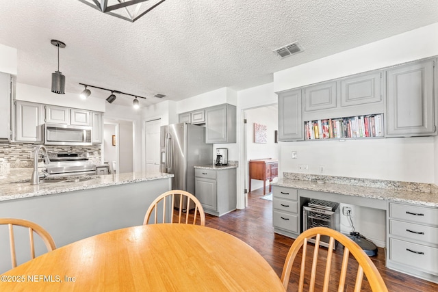 dining room with visible vents, dark wood-style floors, built in desk, and a textured ceiling