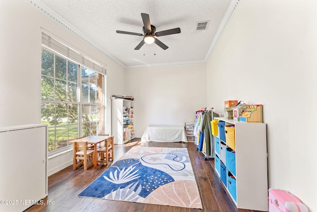 recreation room with visible vents, a textured ceiling, crown molding, and hardwood / wood-style floors