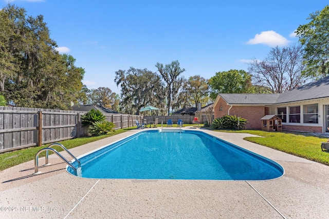 view of swimming pool featuring a yard, a patio, a fenced in pool, and a fenced backyard