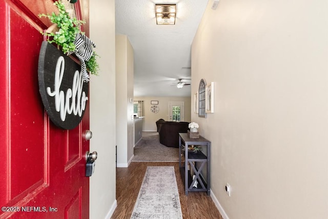 foyer entrance with baseboards, ceiling fan, and wood finished floors