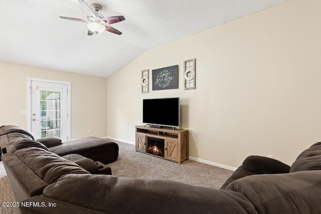 carpeted living room with ceiling fan, a textured ceiling, baseboards, and lofted ceiling