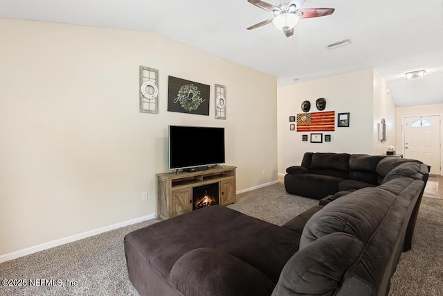 living room with a ceiling fan, visible vents, baseboards, vaulted ceiling, and carpet flooring