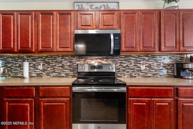 kitchen with decorative backsplash, light countertops, dark brown cabinets, and stainless steel appliances