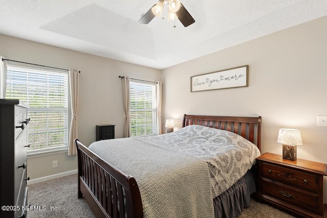 carpeted bedroom featuring baseboards, a textured ceiling, and a ceiling fan