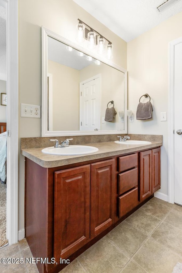 full bath featuring a sink, visible vents, double vanity, and tile patterned floors