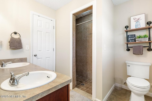 full bathroom with a tile shower, tile patterned flooring, toilet, and a sink