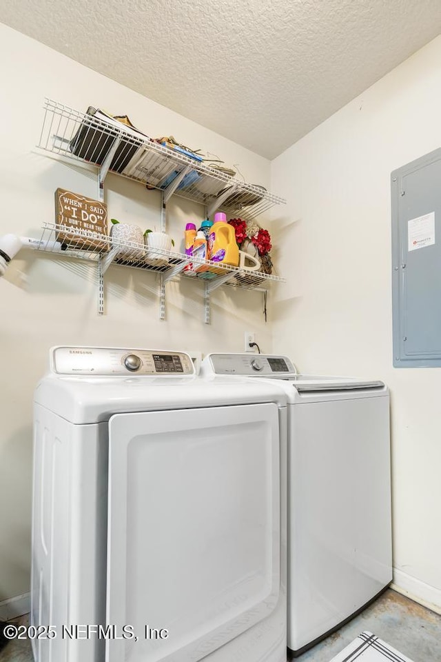 laundry area with electric panel, laundry area, a textured ceiling, and washer and clothes dryer