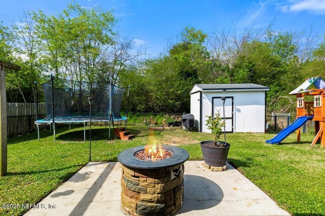 view of yard with an outbuilding, a patio, a playground, and a trampoline