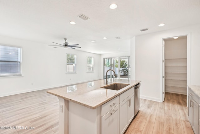 kitchen with a sink, visible vents, light wood-style floors, and open floor plan