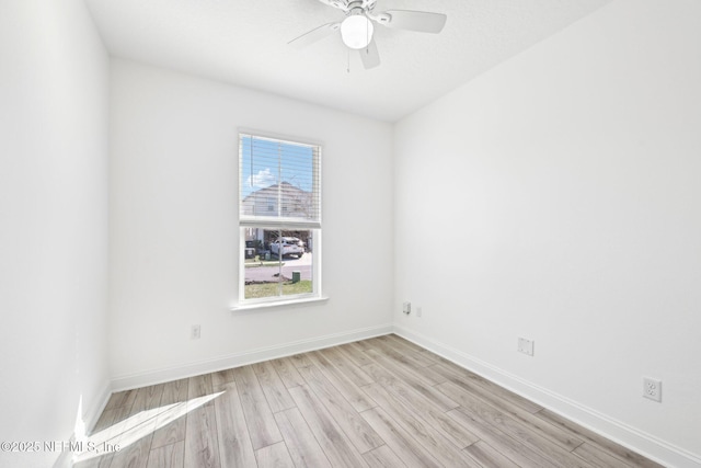 empty room with baseboards, ceiling fan, and light wood finished floors