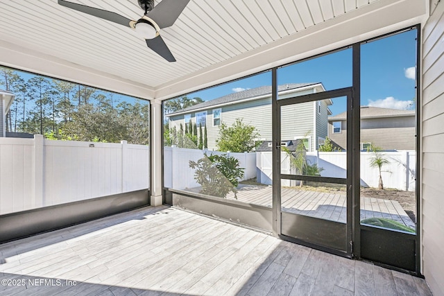 unfurnished sunroom with a ceiling fan