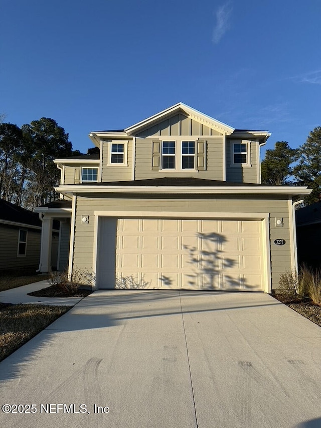 traditional-style house with a garage, board and batten siding, and driveway