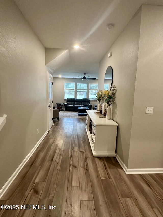 hall featuring dark wood-style floors and baseboards