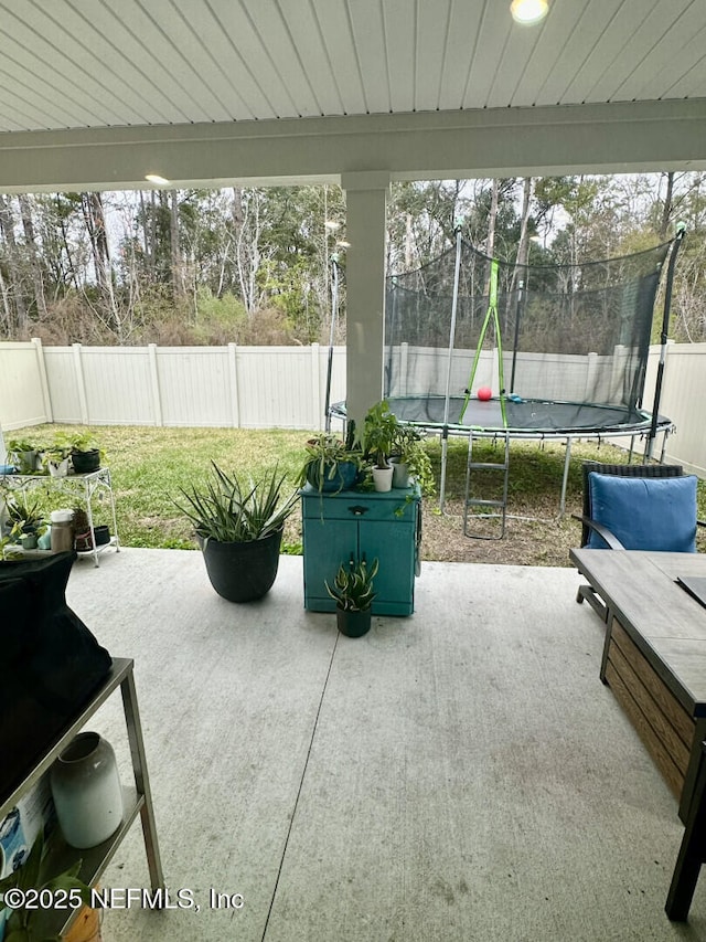 view of patio / terrace with a trampoline and a fenced backyard