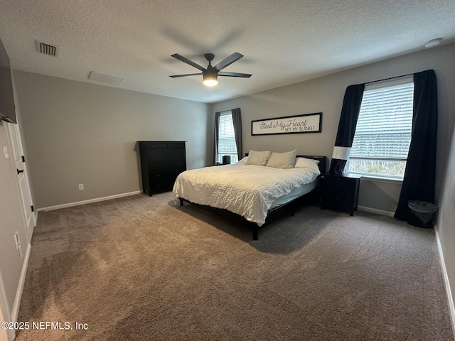 bedroom featuring multiple windows, carpet, visible vents, and a textured ceiling