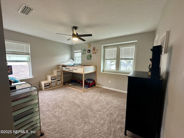 bedroom featuring baseboards, visible vents, a textured ceiling, and carpet