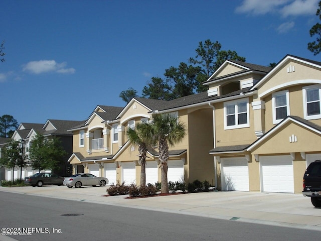 townhome / multi-family property featuring stucco siding, driveway, and an attached garage