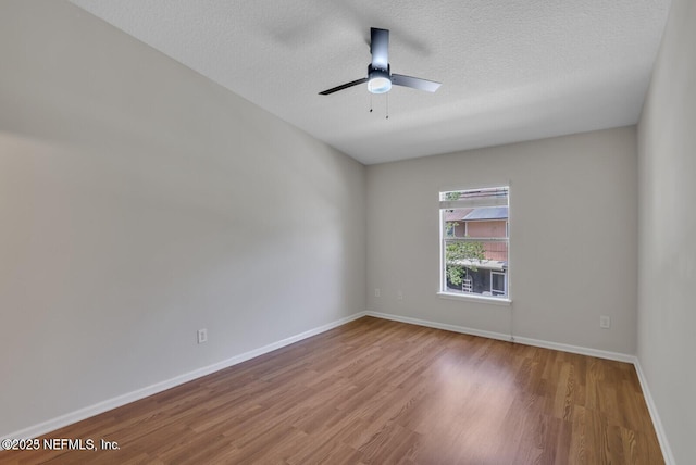 unfurnished room featuring a textured ceiling, a ceiling fan, baseboards, and wood finished floors