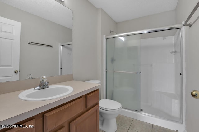 full bath with tile patterned flooring, toilet, vanity, and a stall shower