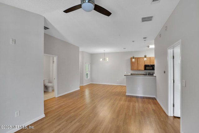 unfurnished living room featuring light wood finished floors, visible vents, ceiling fan with notable chandelier, and lofted ceiling