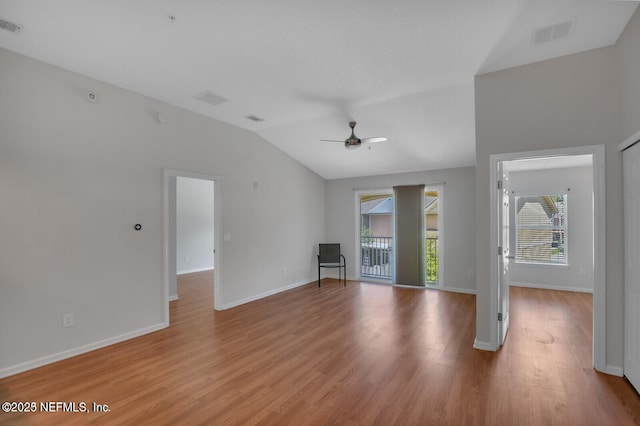 unfurnished living room with light wood finished floors, visible vents, baseboards, and vaulted ceiling