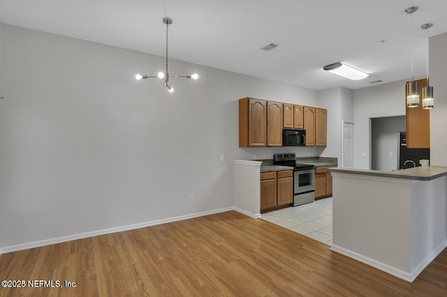 kitchen featuring black microwave, decorative light fixtures, stainless steel electric range oven, light wood-type flooring, and brown cabinetry