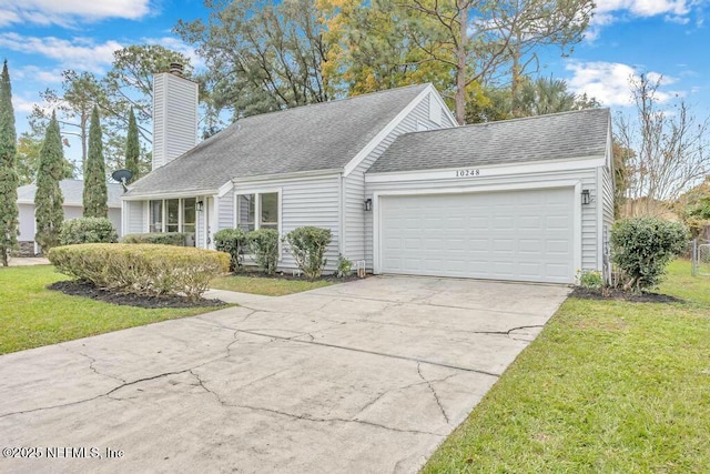 view of front facade featuring an attached garage, a chimney, driveway, and a front lawn