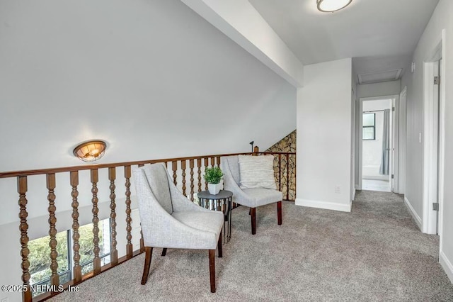 living area with baseboards, carpet floors, attic access, and vaulted ceiling