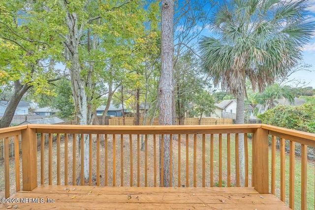 wooden terrace with a lawn and a fenced backyard