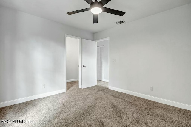 unfurnished bedroom with visible vents, carpet floors, baseboards, and ceiling fan