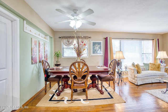 dining room with ceiling fan, wood finished floors, baseboards, and a healthy amount of sunlight