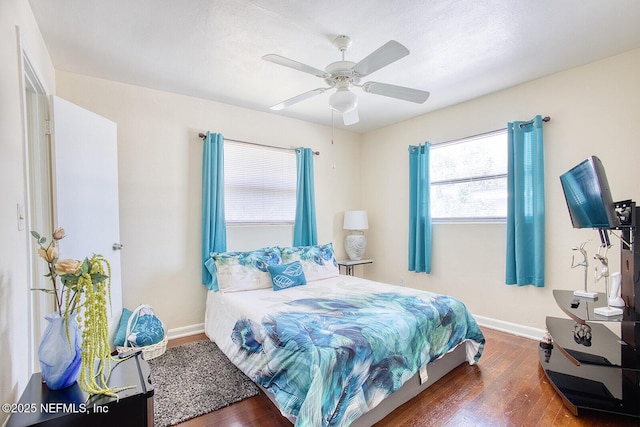 bedroom featuring wood finished floors, baseboards, and ceiling fan