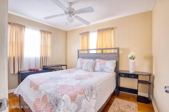 bedroom featuring a ceiling fan, wood finished floors, and baseboards