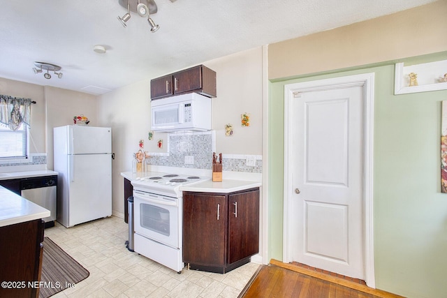 kitchen with dark brown cabinets, white appliances, and light countertops