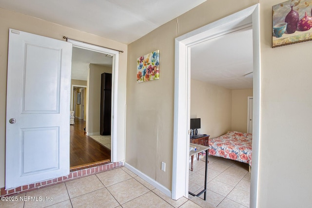 hallway with light tile patterned flooring and baseboards