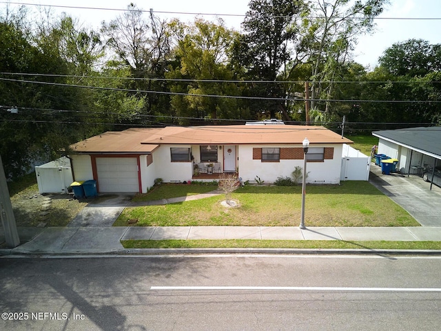 view of front of property featuring driveway, a front lawn, a gate, fence, and a garage