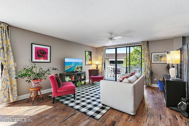 living room featuring baseboards, a textured ceiling, and wood finished floors