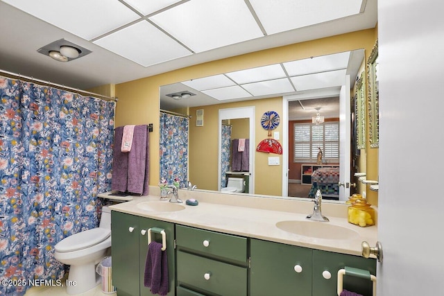 full bath featuring a sink, toilet, and double vanity