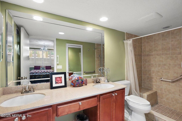 bathroom featuring connected bathroom, tiled shower, toilet, and a sink